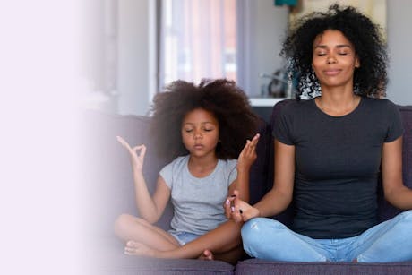 Mother and daughter meditating to promote healthy living